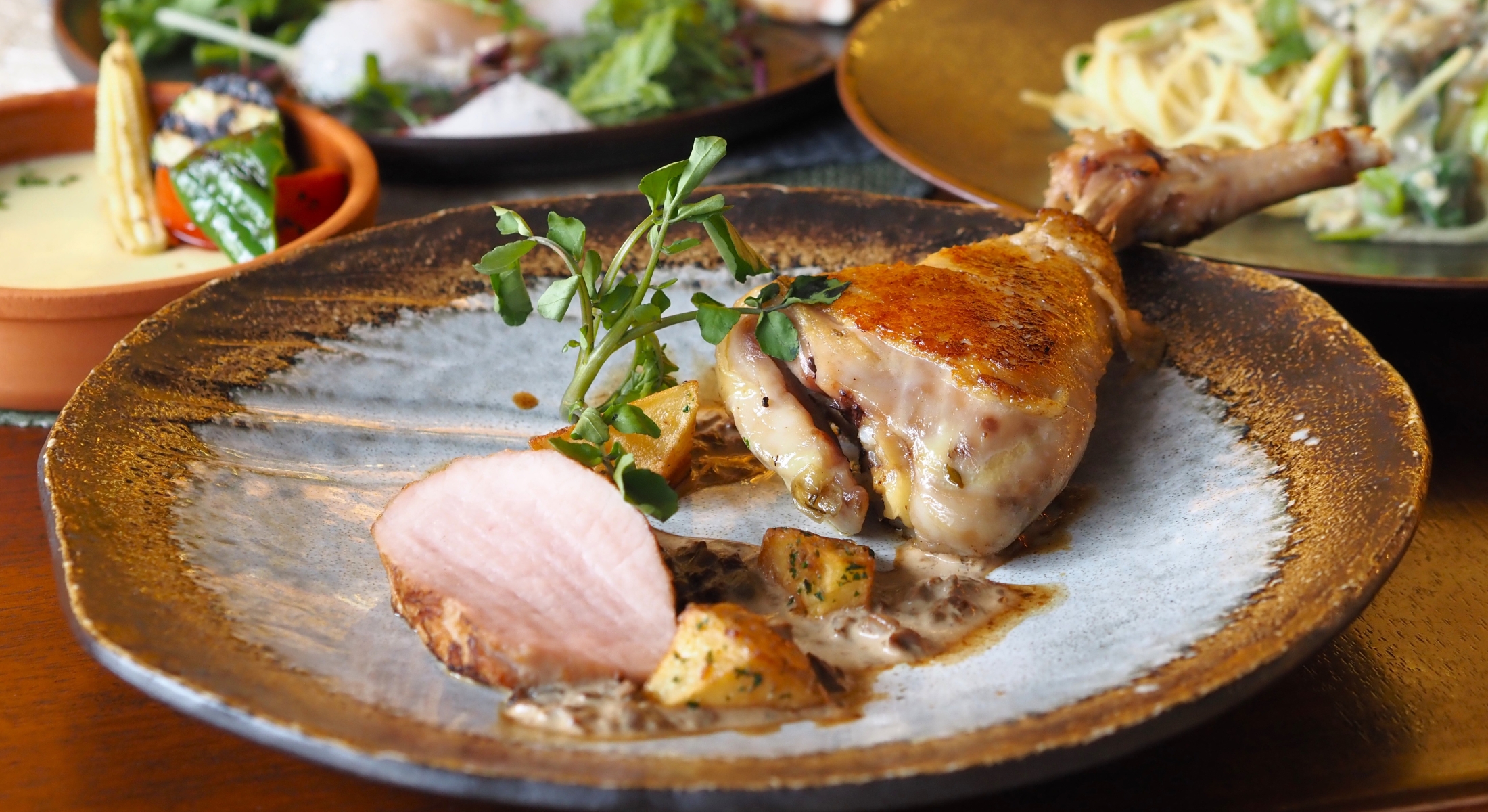 しっとりと仕上げた鶏モモ肉のコンフィと日吉ポークのローストに、ポルチーニソースを合わせた一皿。 Chicken thigh confit and roasted Hiyoshi pork served with aromatic porcini mushroom sauce.