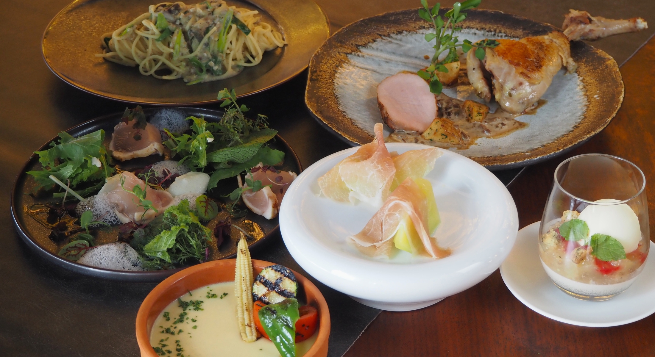 7月限定シーズナルディナーコースのアミューズ、前菜、スープ、パスタ、メインディッシュ、ドルチェがテーブルに並んでいる。